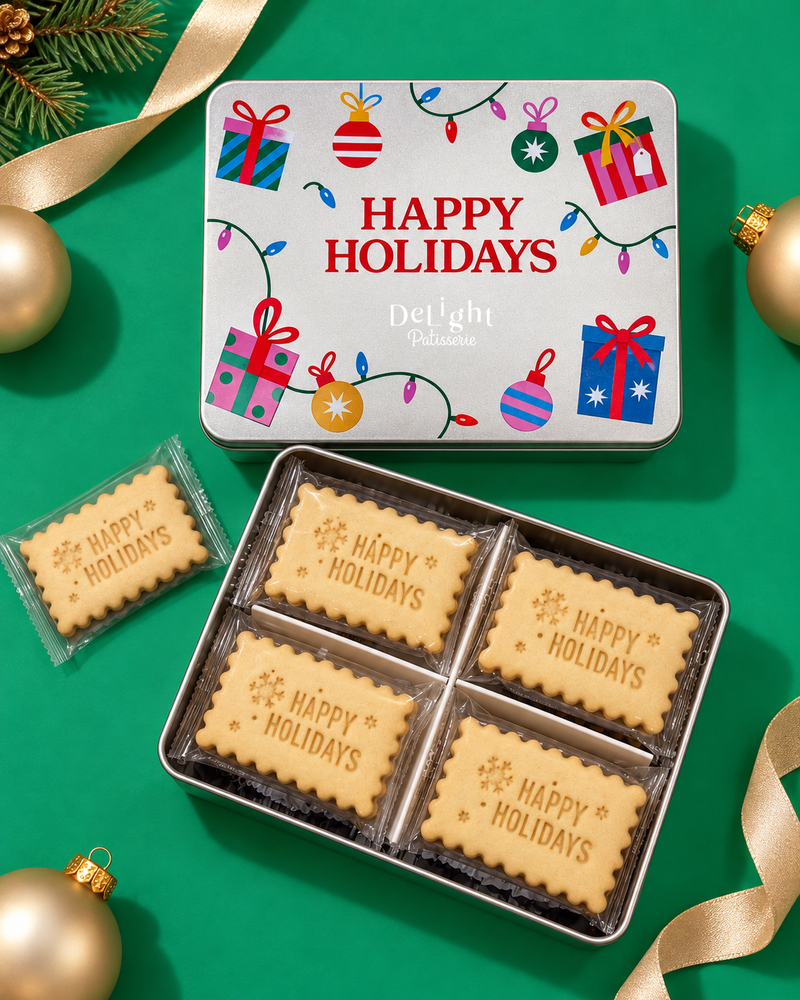 Happy Holidays shortbread cookie tin decorated with colorful presents, ornaments, and holiday lights, filled with individually wrapped shortbread cookies stamped with holiday greetings and snowflakes—a Christmas gift.