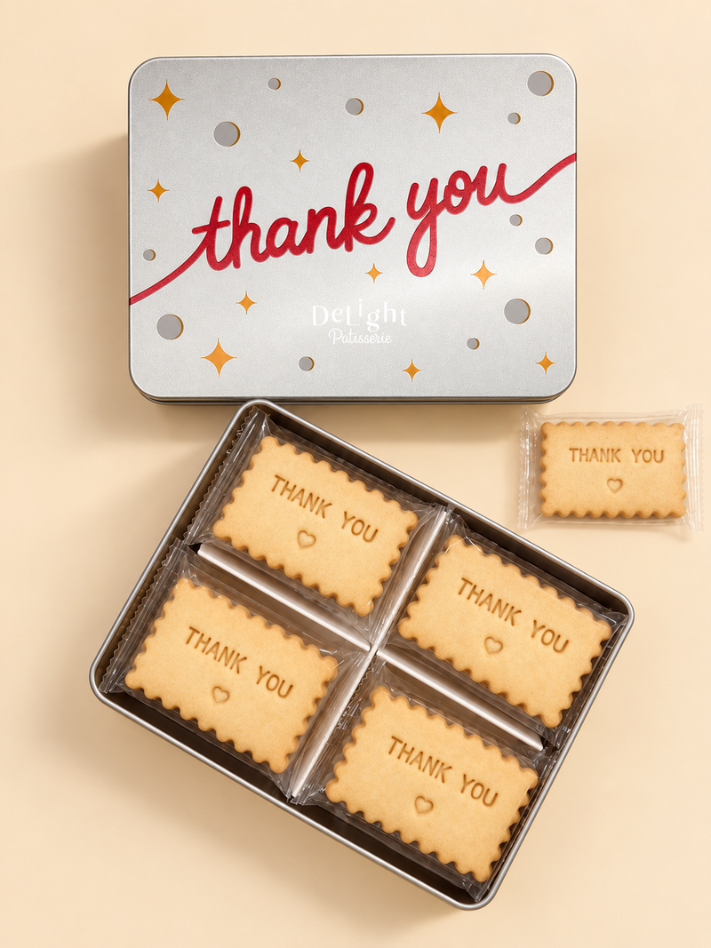 Thank You shortbread cookie tin with red lettering and golden stars, filled with cookies stamped “THANK YOU” and a heart—a thoughtful appreciation gift.