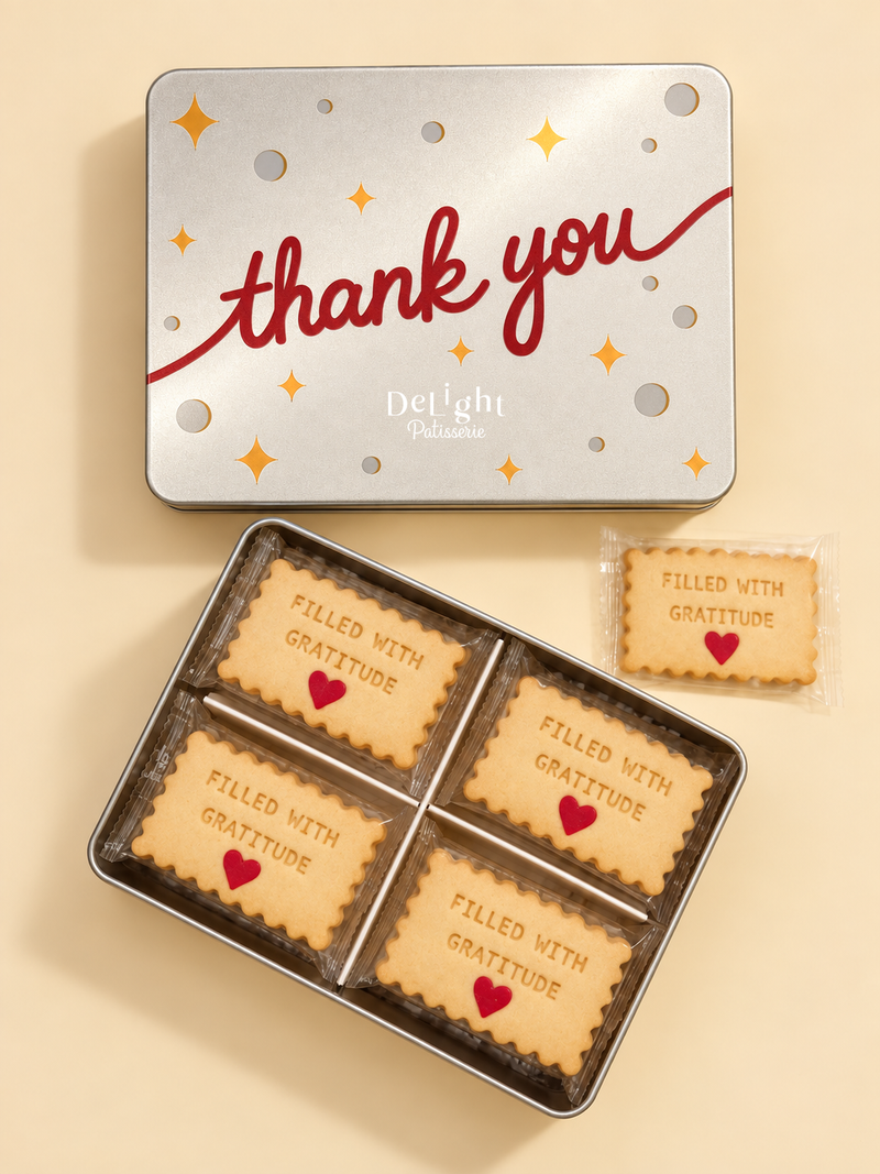 Thank You cookie tin filled with individually wrapped shortbread stamped “FILLED WITH GRATITUDE” and decorated with red sugar hearts —a thoughtful thank-you gift.